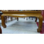 A modern Chinese lacquered mahogany coffee table, the openworked top with a glass panel,