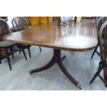 A Regency style mahogany dining table, the three part top with a crossbanded border, raised on twin,