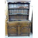 A modern oak dresser, surmounted by a two tier plate rack, over two drawers and two cupboard doors,