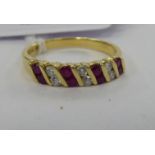 An 18ct gold ruby coloured stone and diamond set half eternity ring 11