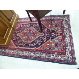 A Persian rug with a central gul on a red ground 70'' x 42'' CS