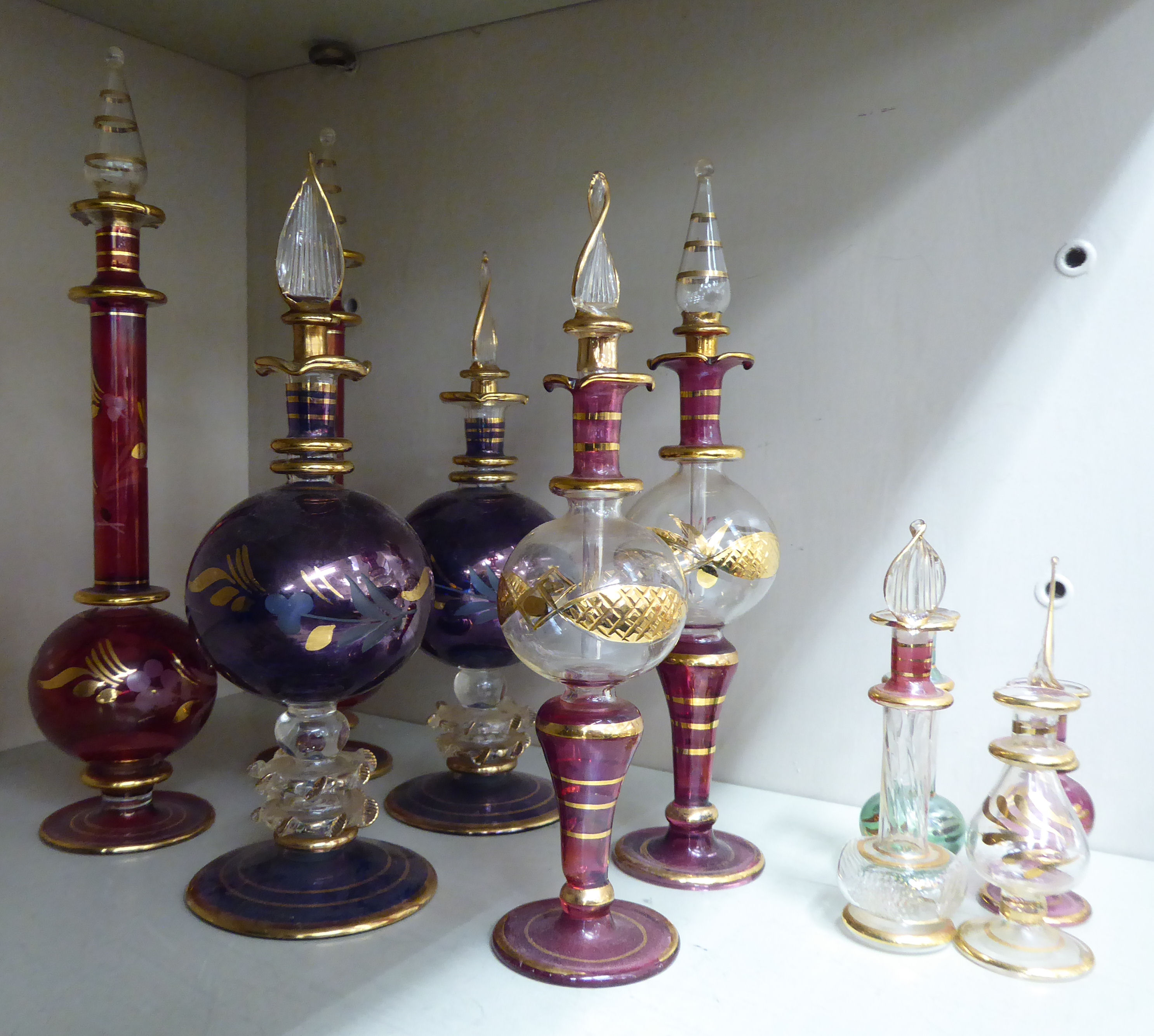 Three pairs of modern part lustre glass pedestal scent bottles with flame finials,