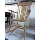 A modern bleached beech framed Windsor rocking grandfather chair with a high lath back,