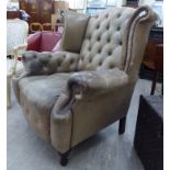 A modern beige coloured hide button upholstered wingback library chair,