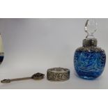 A dimple moulded blue glass perfume bottle with overlaid silver coloured metal shoulders and a