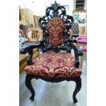 An early 20thC Continental bone inlaid ebony, profusely carved elbow chair,