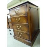 A modern mahogany finished, two drawer filing cabinet, the top set with a tooled green hide scriber,