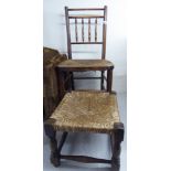 An early 20thC beech framed side chair with a spindle back and a woven rush seat, raised on turned,