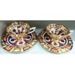 A pair of Royal Crown Derby china trios, decorated in the Imari palette,
