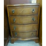 A modern mahogany veneered serpentine front, four drawer chest with drop handles,