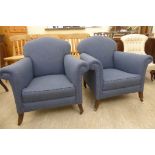 A pair of 1920s fireside chairs with arched, low backs and scrolled, level arms,