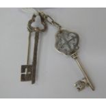 An 'antique' silver coloured metal key design pendant;