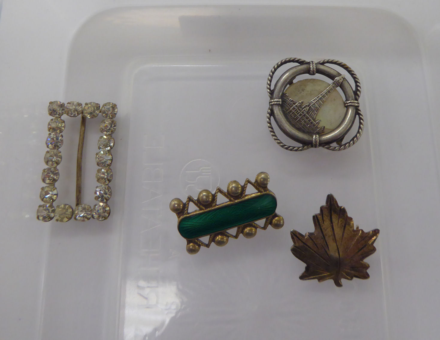 Four dissimilar brooches,