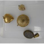 Four dissimilar 'antique' yellow metal lockets: to include one of heart design with floral engraved