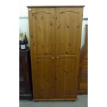 A modern honey coloured pine, two door wardrobe,