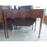 A modern mahogany finished serpentine front serving table, comprising three in-line drawers,