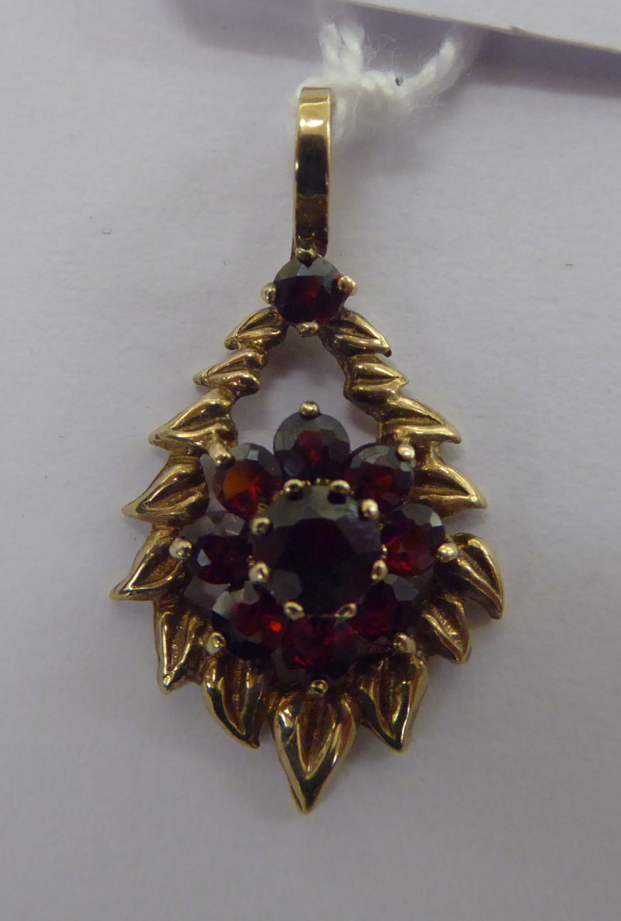 A 9ct gold foliate and garnet set pendant 11