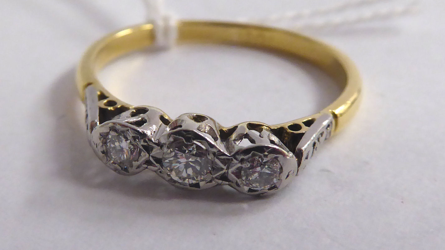 An 18ct gold three stone diamond ring 11