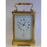 A mid/late 20thC lacquered brass cased carriage clock with bevelled glass panels and a folding top