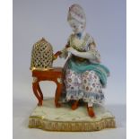 A late 19thC Meissen porcelain figure, a seated woman beside a parrot in a cage,