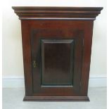 A late Victorian mahogany cabinet with a moulded cornice, over a panelled door,