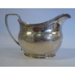 A George III silver oval cream jug with an angular loop handle, an applied wire rim,