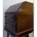 An early 20thC miniature mahogany bureau, the fall flap enclosing a fitted interior,