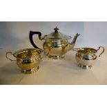 A three piece silver tea set of pedestal bowl design with decoratively cast rims,