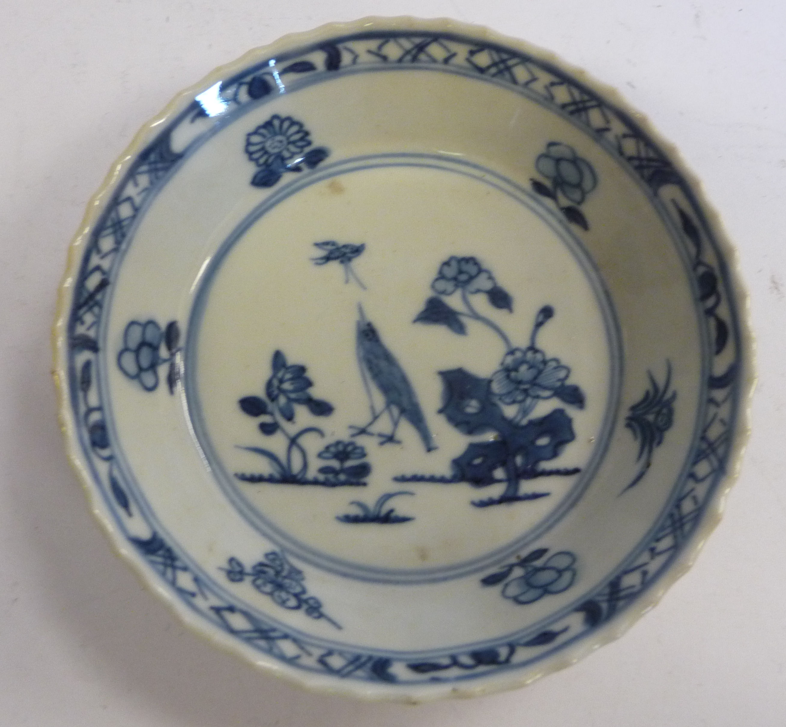 A mid 18thC Chinese porcelain footed dish with angled sides, decorated with a bird,