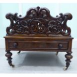 A late Victorian walnut Canterbury, surmounted by four, foliate scroll carved divisions,