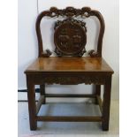 A 20thC Chinese hardwood framed side chair with a low, scroll carved back and a circular splat,