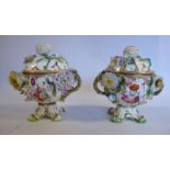 A pair of late 19thC floral encrusted porcelain, twin handled pots with domed covers,