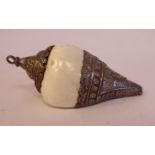 An Oriental white cowrie shell pendant with embossed and chased silver coloured metal mounts