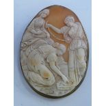 An oval shell carved cameo brooch featuring an allegorical scene with three women gathering shells