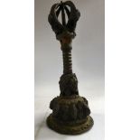 A Tibetan 'antique' bronze prayer bell, variously cast with masks,