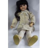 An early 20thC German bisque head doll with painted features and weighted sleeping eyes,