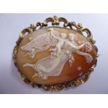 An oval shell carved cameo brooch, featuring an ethereal scene with an angel and a cherub,
