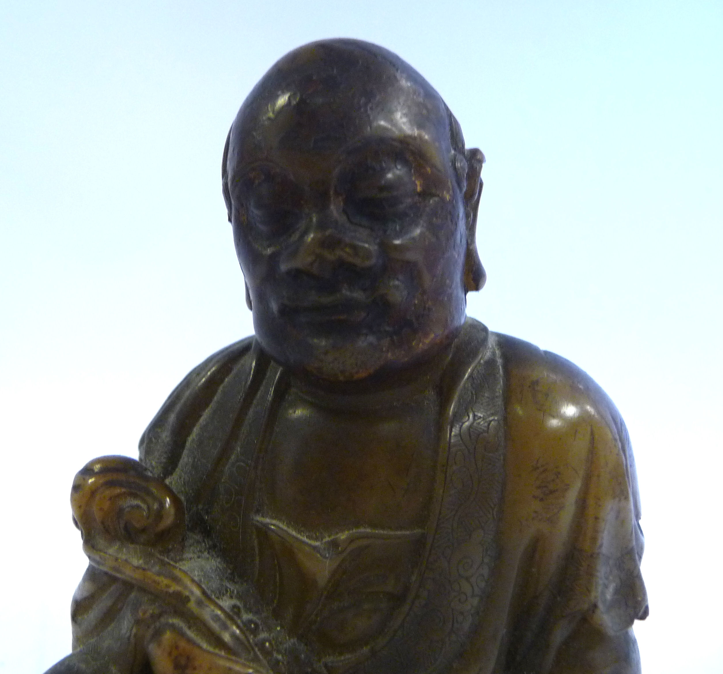 A 19thC Chinese carved brown soapstone seated, robed figure holding a lotus flower, - Image 6 of 6