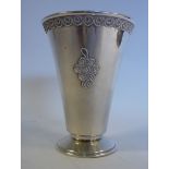 A foreign silver coloured metal beaker vase of tapered form, on a splayed footrim,