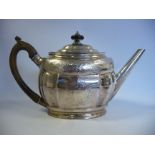 A George III silver oval teapot of panelled, bulbous form with a straight, angled, tapered spout,