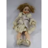 An early 20thC Simon & Halbig bisque head doll with painted features and weighted sleeping eyes,