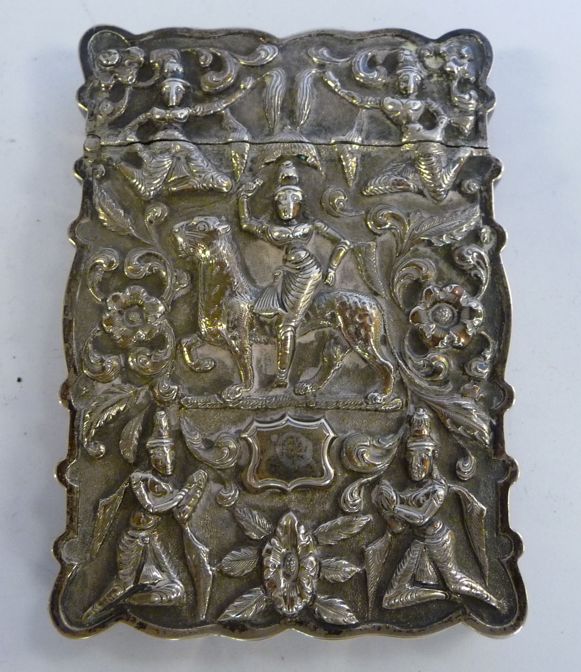 An early 20thC Asian white metal card case of shaped outline, having a hinged cap,