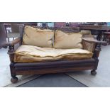 An early 20thC carved oak framed, two seater bergere settee,