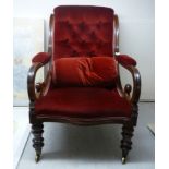 A late Victorian mahogany showwood framed chair with a scrolled, level back and open arms,