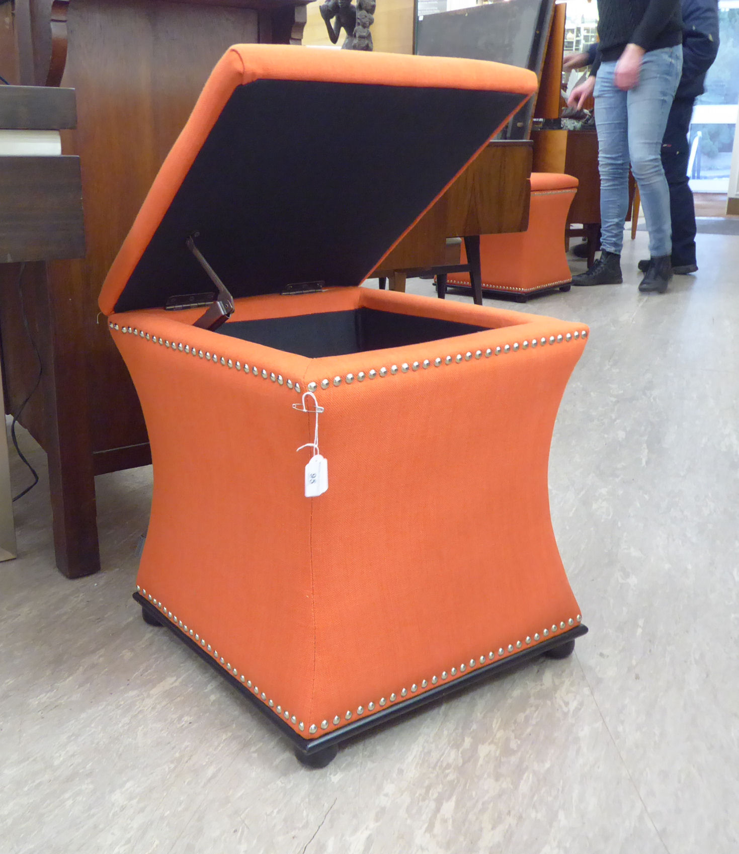 A Regency design box ottoman stool of waisted square form with a hinged top, on button feet,