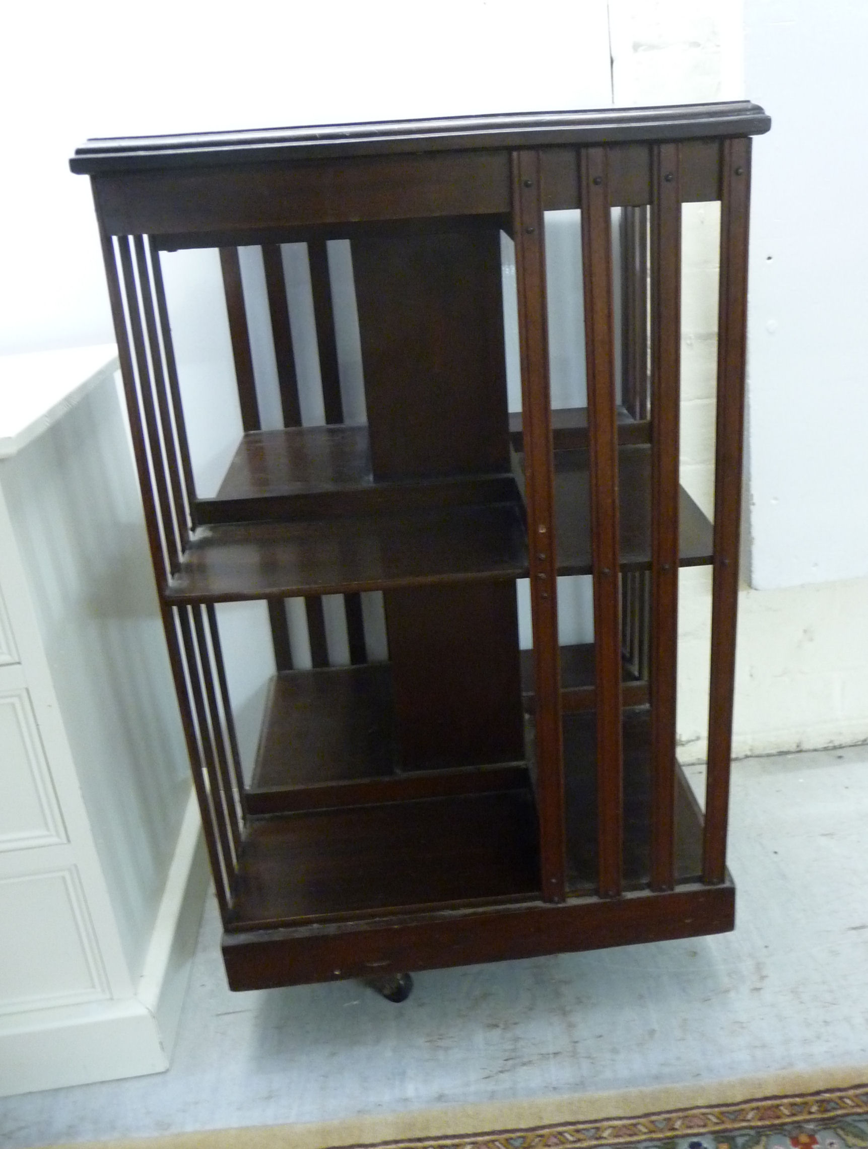 An Edwardian mahogany two tier revolving bookcase with slatted sides,