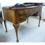 An early 20thC Queen Anne style figured and feather inlaid walnut kneehole desk,