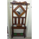A 1920s stained oak mirrored hallstand with four hooks,