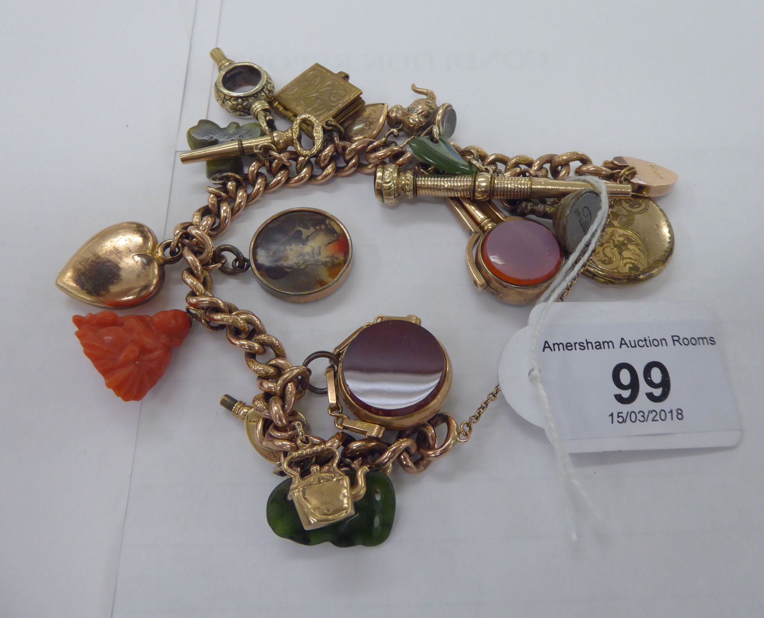 A 9ct gold curb link charm bracelet with seventeen gold and yellow metal charms 11