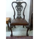 A late 19thC profusely carved spoonback side chair with a pierced scrolled splat and an upholstered